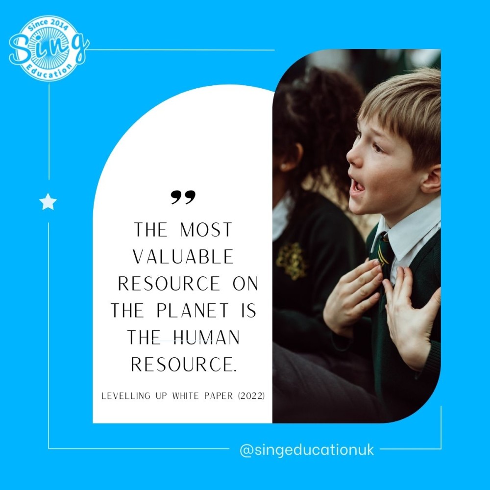 A young student in a green school uniform is captured mid-song, hands on chest, with a look of concentration and joy, embodying the quote "The most valuable resource on the planet is the human resource" from the Levelling Up White Paper (2022), shared by Sing Education to emphasize the importance of nurturing human potential through education.
